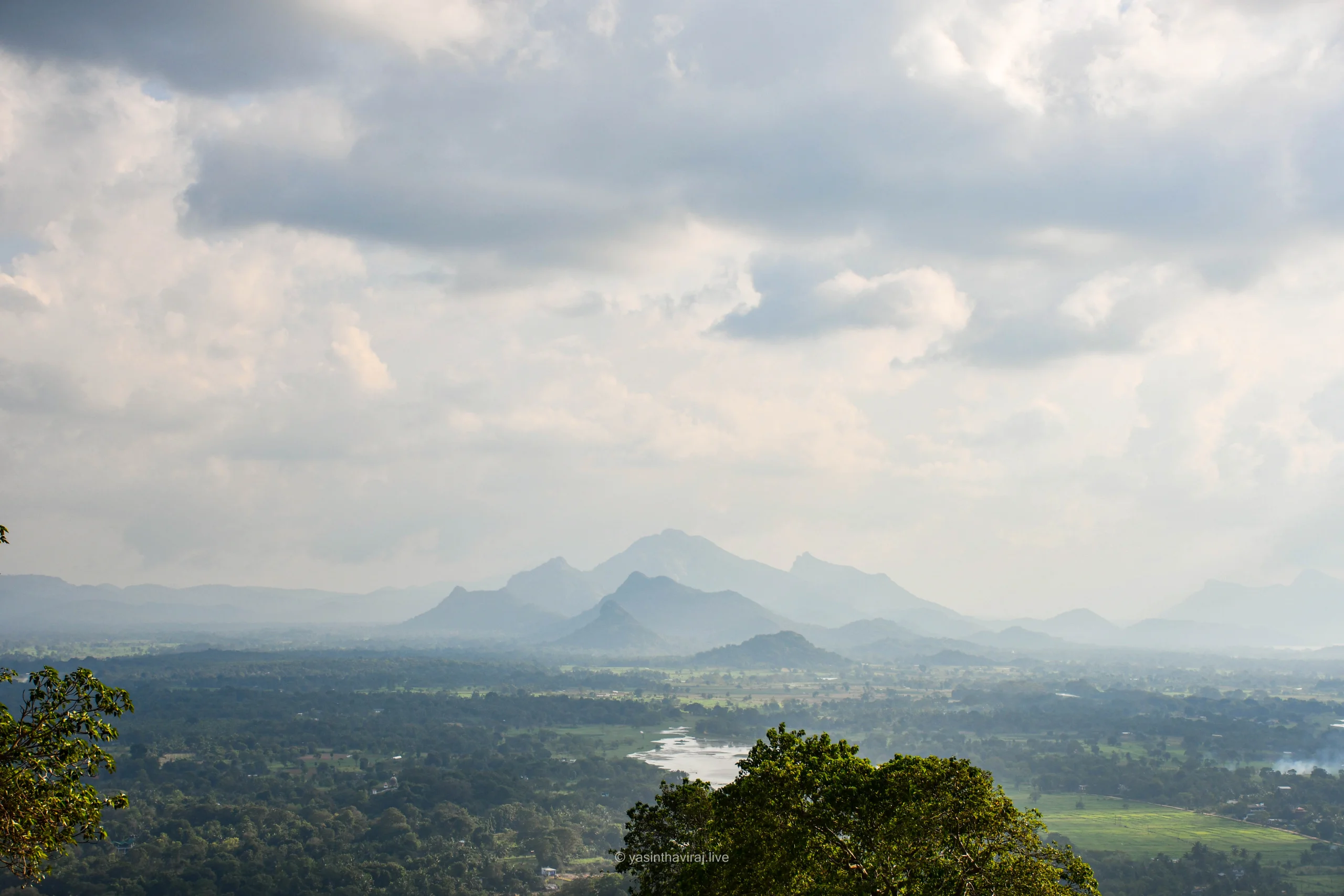 Misty scenic view with sun rays from Sigiriya rock fortress